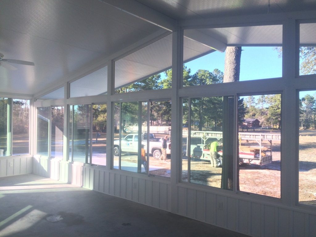 Custom sunroom addition on a Brunswick Georgia home surrounded by coastal live oaks in morning light.