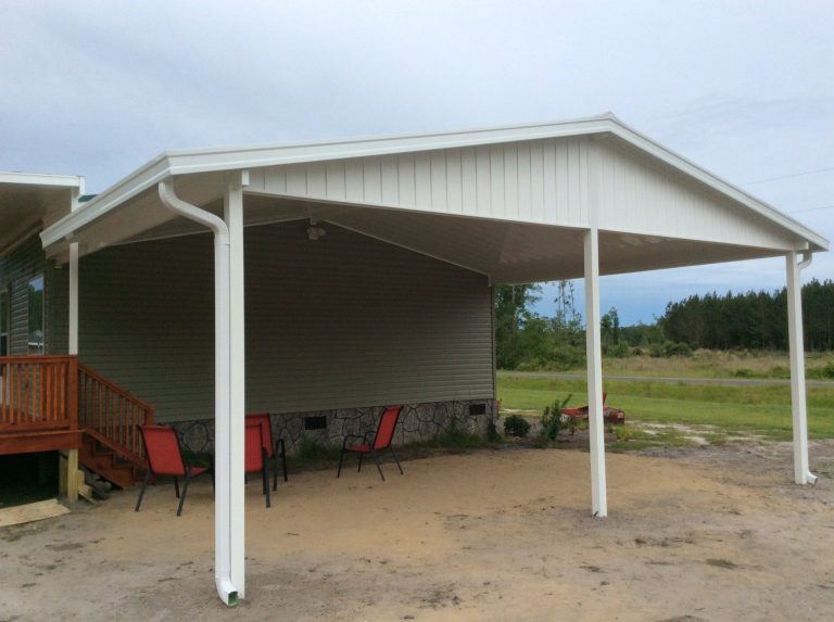 Freestanding carport over a concrete driveway pad in a St. Simons residential neighborhood.