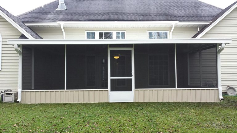 Screen room addition on a Waycross Georgia home surrounded by high tree canopy in summer.