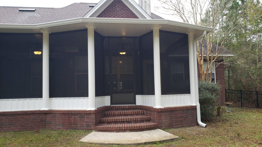 Aluminum-framed screen room on a St. Simons Island home surrounded by live oak canopy in summer.