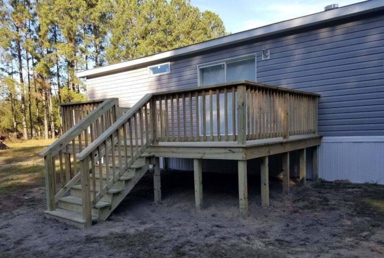 Pressure-treated deck with railings and steps in Pierce County Georgia backyard.