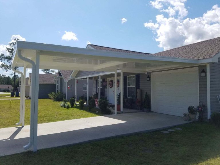 Custom aluminum carport installed on Waycross Georgia home surrounded by dense tree canopy