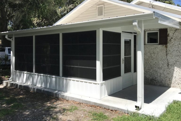 Vinyl glazed track panels closed on a Claxton Georgia porch during a passing afternoon rainstorm.
