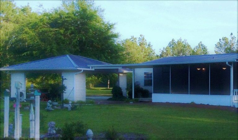 Steel carport covering vehicles on a Toombs County property in Lyons Georgia.