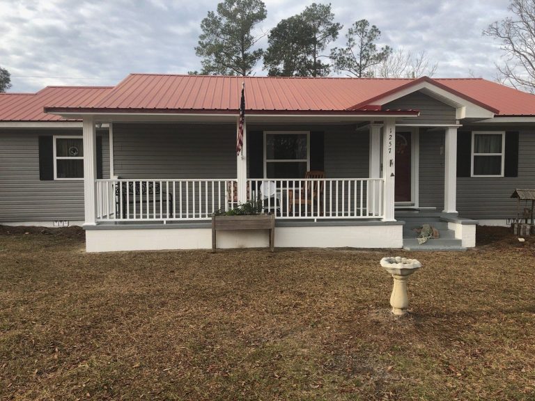 Covered wood porch addition on a McIntosh County home with decorative columns and screened walls.