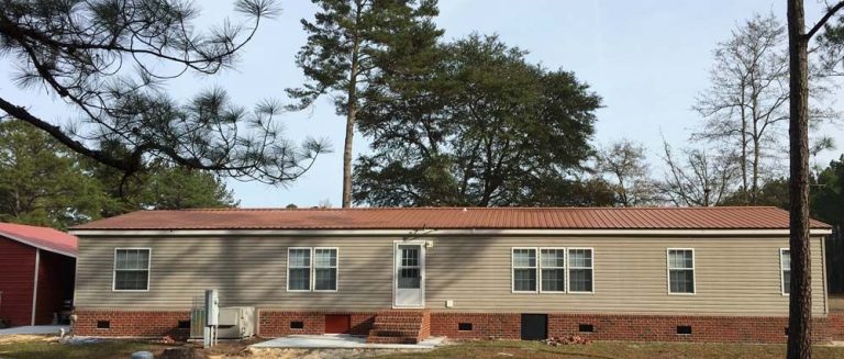 Galvalume metal roof installed on a Pierce County Georgia home surrounded by mature tree canopy