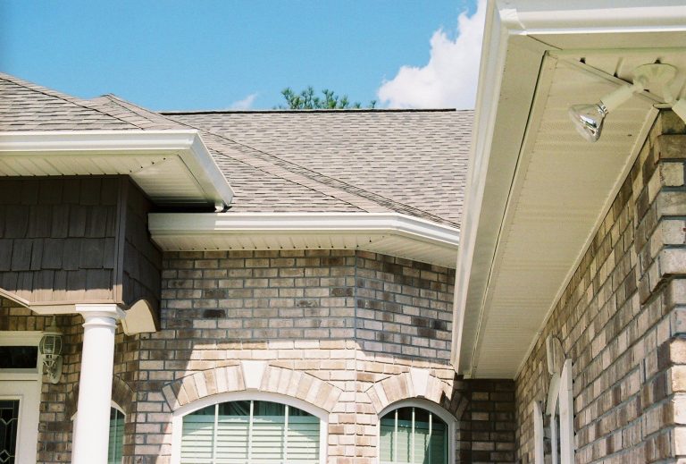 Eicher's Pro Vinyl crew installing seamless gutters on a Glynn County residential roofline.