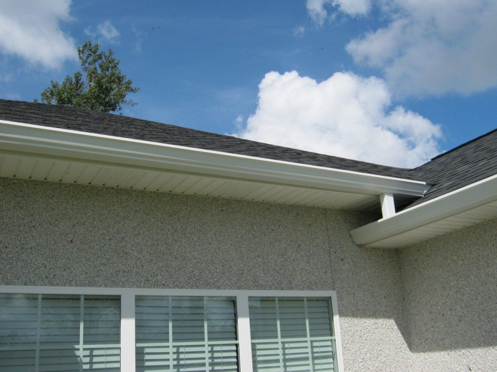 Seamless gutters handling heavy rainfall on a McIntosh County home with coastal hurricane exposure.