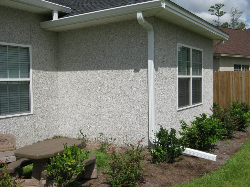 Seamless aluminum gutters installed on a Lyons Georgia home under a dense Toombs County tree canopy.