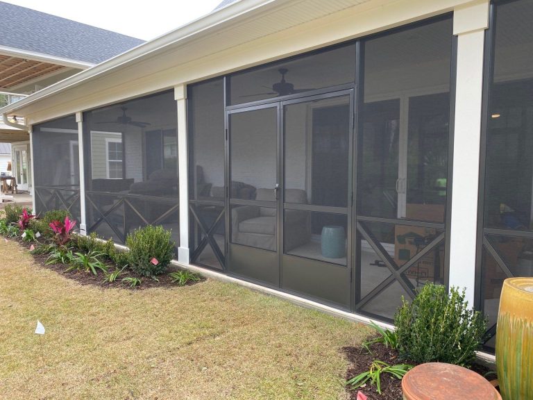 Custom screen room addition on Springfield Georgia home surrounded by mature tree canopy in summer.