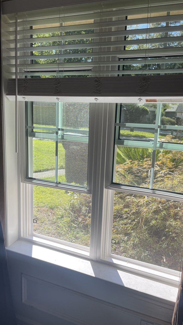 Close-up of insulated vinyl window frame with extruded aluminum corner reinforcement and gnat-resistant screen.